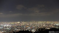 Panorama Sapporo dipayungi langit gelap dan pancaran lampu pada bangunan sukses menggoda perhatian wisatawan yang menyesaki kereta selagi melaju perlahan (Baban/detikTravel)