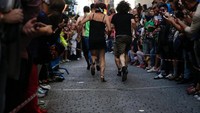 Para pria berlomba dengan semangat walau jalanannya sempit dan ramai dengan penonton (Juan Medina/Reuters)
