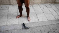 Terlihat peserta melepaskan sepatunya dan membiarkan tergeletak di jalan. Kakinya sakit ya? (Juan Medina/Reuters)