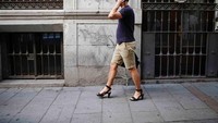 Seorang pria sedang menelfon sebelum mengikuti lomba. Dia telah mengenakan high heels! (Juan Medina/Reuters)