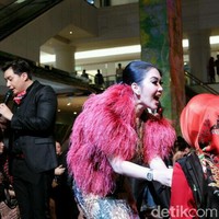 Syahrini yang tampil cetar dengan bulu-bulu merah di bahunya bersalaman dengan tamu undangan peluncuran parfumnya dan pesta ulang tahunnya. Foto: Anggi Mayasari