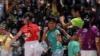 Anak-anak bermain di pertunjukan Bubble Up yang ada di luar Harbour City mall (Foto: REUTERS/Bobby Yip)
