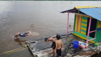 Foto: Pada salah satu sisi tepian sungai banyak anak-anak kecil asyik bermain. Ada perempuan, tapi lebih banyak anak laki-laki. Mereka melompat dari semacam rumah kecil terapung yang ditambatkan dengan tali ke tepian (Kurnia/detikTravel)