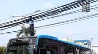 Petugas TransJakarta menggulung kabel yang sempat pengganggu pengguna jalan.