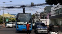 Petugas TransJakarta menarik dan menggulung kabel yang melintang di perempatan Taman Menteng.