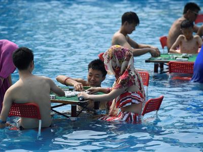Foto Dampak Gelombang Panas di China, Main Mahjong Pun Sambil Berendam