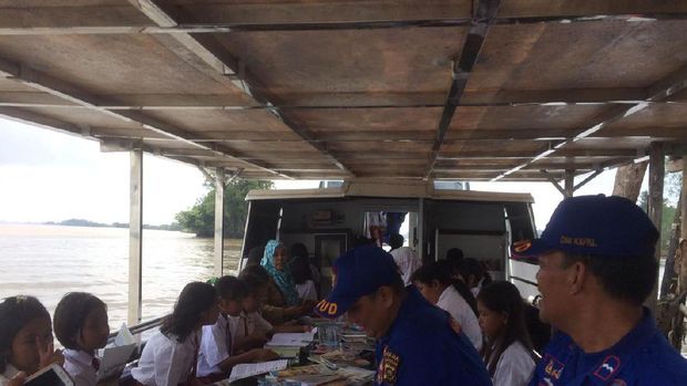 Anak-anak sekolah sangat antusias membaca buku di perpustakaan terapung itu.