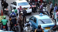 Para penumpang kereta yang menyeberang jalan juga menyebabkan lalu lintas tersendat.