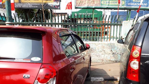 Terlihat sejumlah mobil yang parkir di atas trotoar jalan.