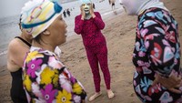 Facekini mirip dengan balaclava dengan lubang yang ada untuk mulut dan mata. Bahan yang digunakan untuk membuat facekini umumnya menggunakan kain sintetis ringan seperti poliester. Foto: (Kevin Frayer/Getty Images)