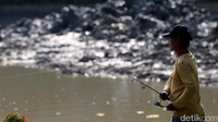 Beberapa warga terlihat memancing saat pengerukan berlangsung.
