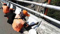 Tiga orang petugas melakukan pengecatan.