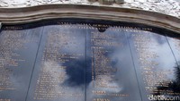 Setangkai bunga diletakkan di depan monumen.