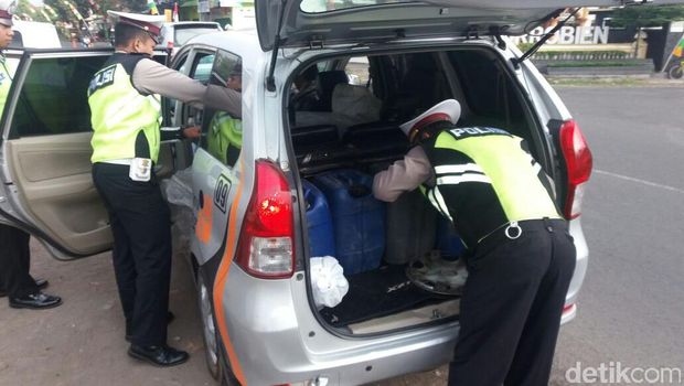 Petugas memeriksa mobil yang membawa 300 liter ciu.