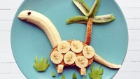 Peanut Butter dan Banana Dino Sandwich dibuat dari pisang yang dibentuk kepala dino, sepotong roti panggang yang di olesi selai kacang. Dilengkapi irisan kiwi yang dijadikan sebagai pohon kelapa.