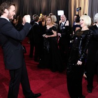 Sesekali Chris mencuri kesempatan untuk memotret istrinya saat sedang berpose di hadapan ratusan fotografer. (Foto: Getty Images)