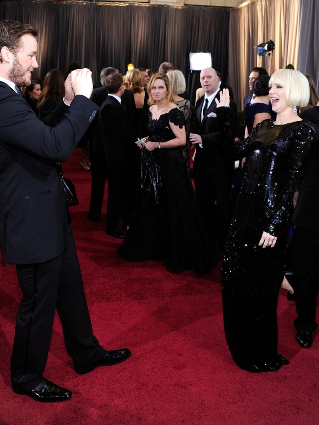 Sesekali Chris mencuri kesempatan untuk memotret istrinya saat sedang berpose di hadapan ratusan fotografer. (Foto: Getty Images)