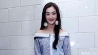 Ia terlihat manis dengan atasan biru yang memamerkan bahu indahnya dan ripped jeans putih. Pool/Noel/detikFoto.