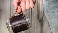 Kalau mau puas minum kopi, gelas mason atau mason jar cocok dipakai. apalagi yang satu ini diberi handle kulit dan pegangan tembaga yang berkesan ‘macho’. Foto: Istimewa