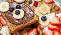 Teddy Bear Toast dibuat dari roti panggang dengan selai kacang yang ditambahkan pisang, apel, dan buah beri. Dibentuk wajah beruang yang lucu.