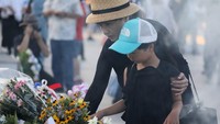 Foto: Orang-orang sudah ramai datang sebelum acara memorial dimulai. Mereka memang banyak berdoa di sana dan membawa buket bunga. Karangan bunga pun berjejer di depan tugu (Jiji Press/AFP)