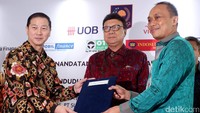 Presiden Direktur PT Bank UOB Indonesia, Kevin Lam, menyerahkan naskah kerjasama kepada Dirjen Dukcapil Kemendagri, Zudan Arif Fakhrulloh, disaksikan Menteri Dalam Negeri (Mendagri) Republik Indonesia, Tjahjo Kumolo, usai penandatangan kerjasama, di Jakarta, Senin (7/8/2017).