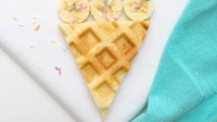 Waffle Ice Cream Sundaes menampilkan irisan wafel segitiga dengan irisan pisang dan taburan meisjes yang dibentuk menyerupai ice cream cone.
