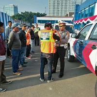 Kasatlantas Polrestabes Bandung memasang rompi kepada 'Pak Ogah'.