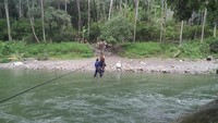 Cara Serka Darwis menyeberangkan anak sekolah di atas sungai, sebenarnya cukup berbahaya.  (Foto: Istimewa)