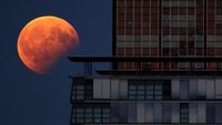 Gerhana bulan sebagian tertangkap kamera di sebelah sebuah gedung di Berlin, Jerman (Foto: REUTERS/Hannibal Hanschke)