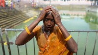 Setelah berkorban, mereka kemudian mandi membersihkan kepala yang siap dicukur. Barulah mereka memanjatkan doa kepada Dewa (Arun Sankar/AFP)5