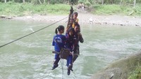 Hampir setiap hari, dia harus menantang maut demi membantu siswa dan warga setempat menyeberangi Sungai Rante Angin yang terletak di Desa Maroko. (Foto: dok Istimewa)