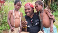 Maximus Tipagau, salah seorang tokoh pemuda setempat menunjukan gadget ke anak-anak suku Moni. Dia memiliki operator pendakian Adventure Carstensz yang melayani pendakian ke Puncak Carstensz, puncak tertinggi di Indonesia salah satu Seven Summit dunia (Afif Farhan/detikTravel)