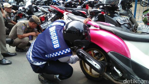  Petugas menggembosi ban motor di Kebayoran Baru, Jaksel, Rabu (9/8/2017)