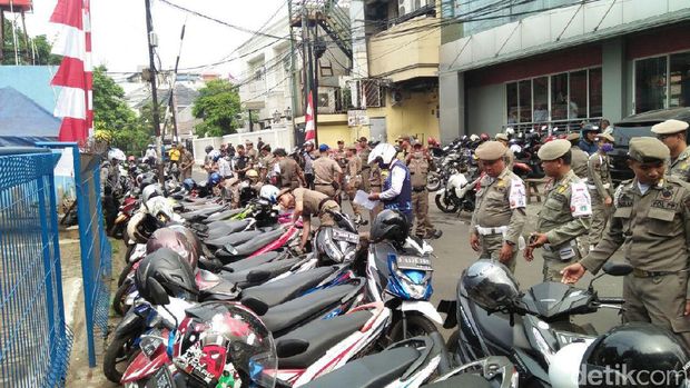 Petugas menggembosi ban motor di Kebayoran Baru, Jaksel, Rabu (9/8/2017)