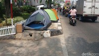 Tenda-tenda mereka terpasang tepat di atas trotoar di depan Rumah Detensi Imigrasi Jakarta. Sedangkan kondisi jalan cukup padat, truk-truk hilir mudik melintas. (Foto: Arief Ikhsanudin/ detikcom)