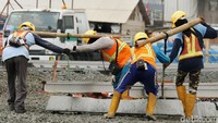 Pekerja menggotong bantalan untuk rel MRT.