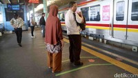 Dua orang penumpang menunggu kedatangan KRL.