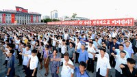 Sambil meneriakan yel-yel, mereka melakukan salam dengan tangan terkepal. KCNA/via REUTERS.