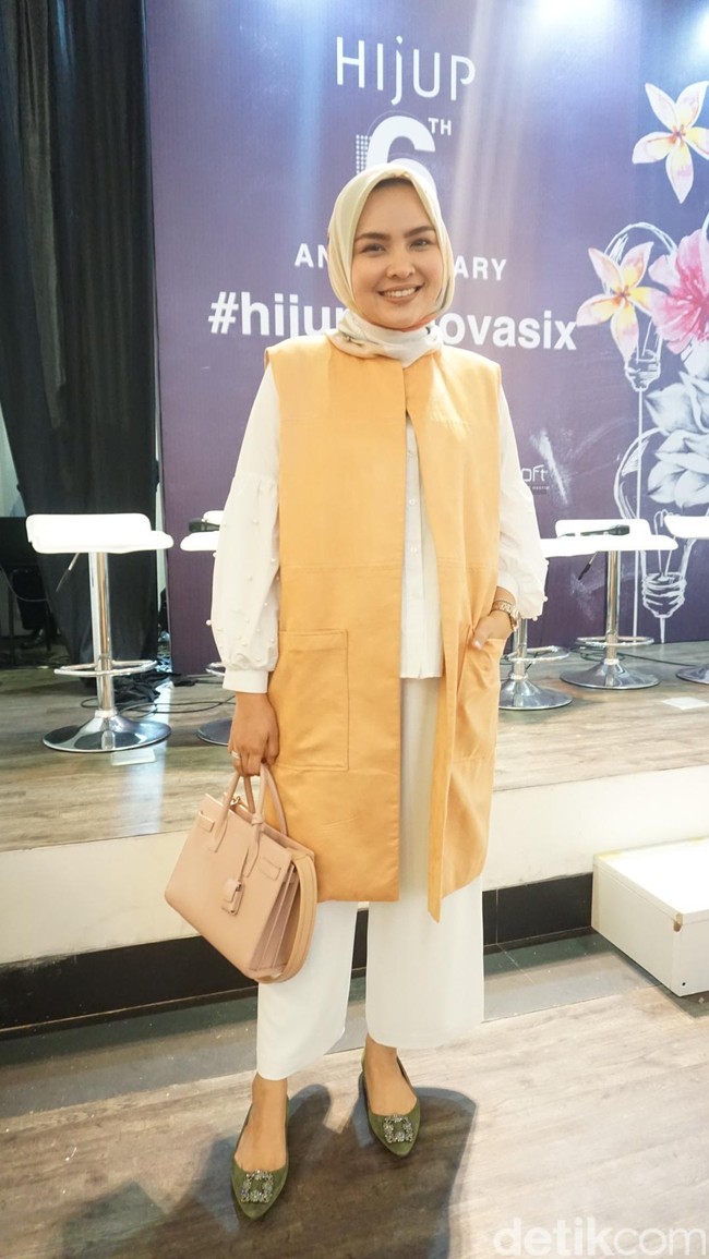 Desainer Ria Miranda turut hadir dalam setelan off white dan vest warna oranye muda. Foto: Dok. Arina Yulistara/Wolipop