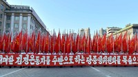 Mereka membentangkan spanduk dan mengibarkan bendera. KCNA/via REUTERS.