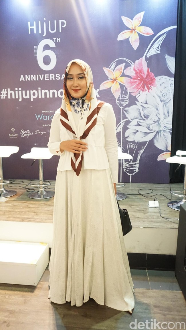 Desainer Dian Pelangi juga datang tampil feminin mengenakan setelan blouse putih dan rok ruffle. Satin scarf menjadi pilihan untuk tampil elegan. Foto: Dok. Arina Yulistara/Wolipop