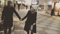 Pasangan ini mengenakan mantel dengan warna yang senada, yakni hitam. Di depan umum, Enji dan sang istri bergandengan tangan. Dok. Instagram/rosmanizar_baskoro