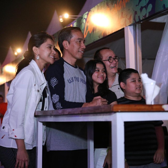 Jokowi memadukan kaus We The Fest tersebut dengan celana jeans warna gelap. Tampak bagian lengan kaus dihiasi gambar daun kelapa yang menjadi ciri khas We The Fest. Foto: Hanif Hawari/detikHOT