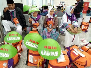 Gaya Beda Calhaj Cilacap, Pakai Caping Jadi Perhatian di Bandara