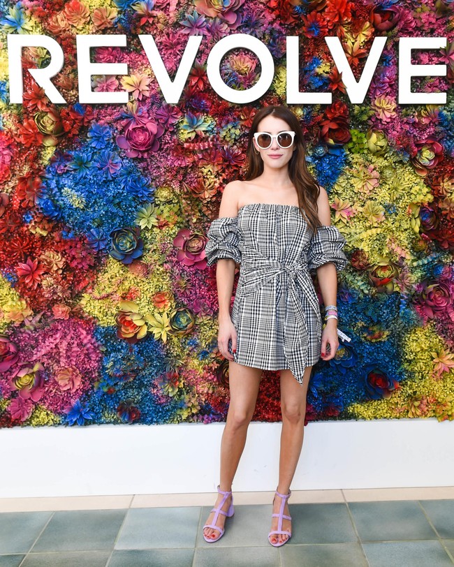 Dress pendek off the shoulder ala Emma Roberts ini jadi lebih fashionable saat dipadukan dengan sandal warna bold.