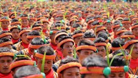 Peserta tarian ini tidak diperbolehkan mengenakan alas kaki dan duduk di atas rumput. Beberapa panitia sibuk mengatur peserta agar terlihat rapi (Agus/detikTravel)