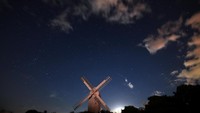 Hujan meteor ini banyak terlihat di langit Inggris. Salah satunya di Brighton, sisi selatan Inggris. Hujan meteor terlihat di atas sebuah kincir angin. (REUTERS/Hannah McKay)