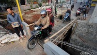 Para pengendara sepeda motor melewati jembatan darurat, Senin (14/8/2017).