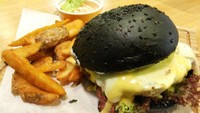  Burger hitam terlihat gothic karena memakai roti hitam legam. Di Blacklisted, roti burger hitam dibuat dengan charcoal. Isiannya beef patty, lelehan keju mozzarella, beef bacon dan onion rings.  Foto: dok.detikFood/Istimewa